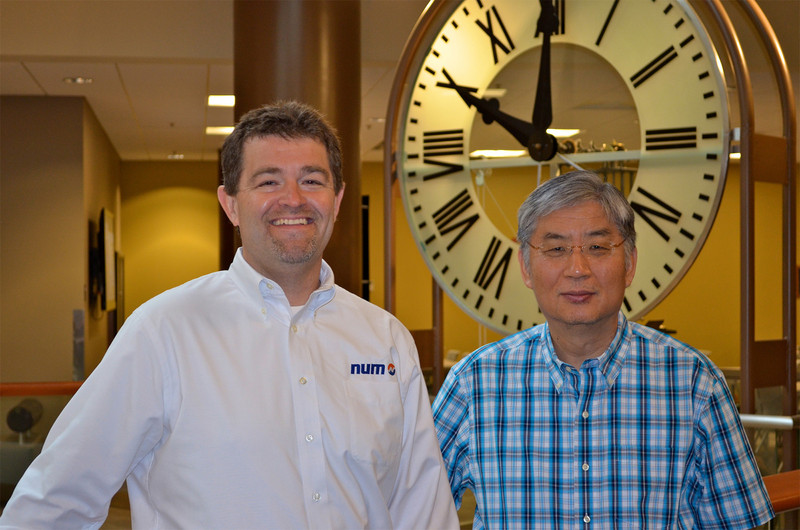 Steven Schilling (a sinistra), Managing Director di NUM Corporation, e Yung C. Shin (a destra), Professore di Ingegneria Meccanica alla Purdue University, in piedi davanti allo storico orologio dell'università nella Heavilon Hall.